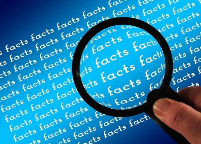 Magnifying glass held over repeated word "facts"